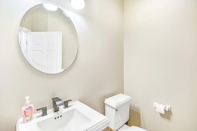 half bathroom with toilet and a sink