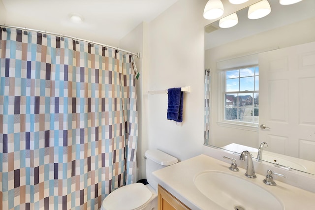 bathroom featuring toilet, vanity, and a shower with shower curtain