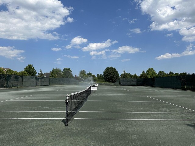 view of tennis court featuring fence