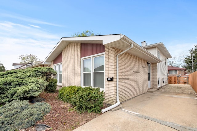 742 Newell Ave, Calumet City, IL 60409 - view of home's exterior featuring a chimney, brick siding, fence, and concrete driveway