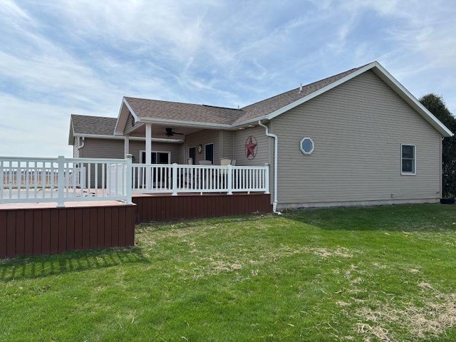 rear view of property with a lawn, a wooden deck, and ceiling fan