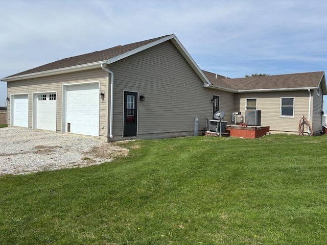 rear view of property featuring a lawn and a garage