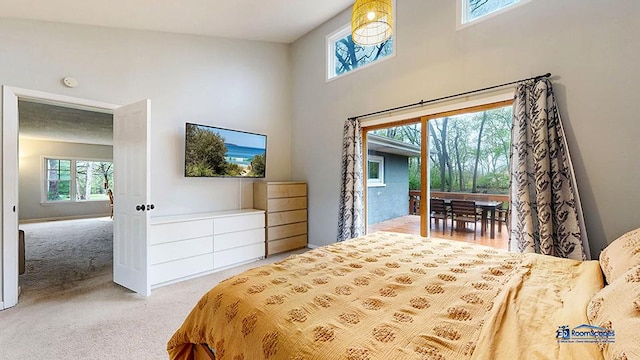 bedroom featuring carpet floors, access to outside, multiple windows, and a towering ceiling