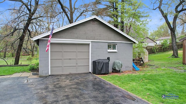 detached garage with fence and aphalt driveway