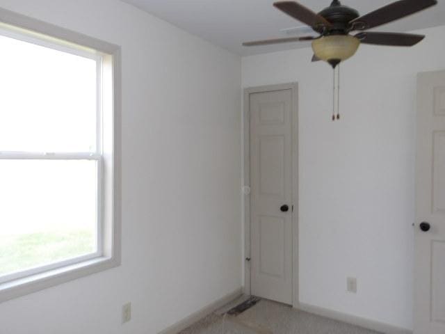 908 Merrill Ave, Loves Park, IL 61111 - unfurnished room featuring a ceiling fan, baseboards, and a wealth of natural light
