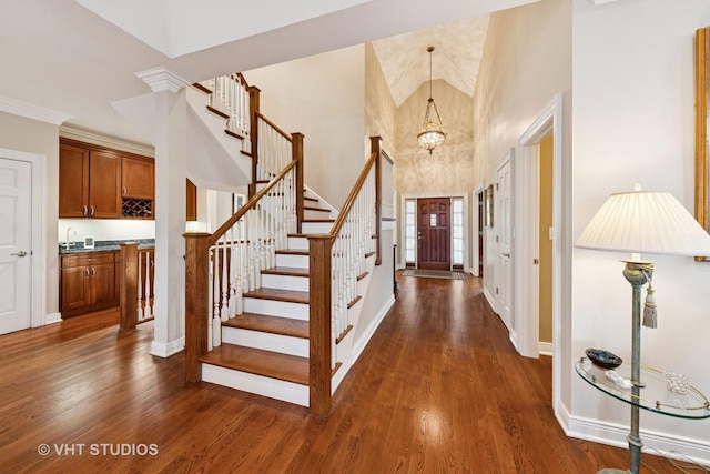 21819 W Riviera Ct, Mundelein, IL 60060 - foyer with a towering ceiling, stairway, a chandelier, dark wood-style flooring, and baseboards
