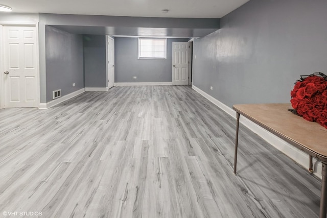 basement featuring baseboards, wood finished floors, and visible vents