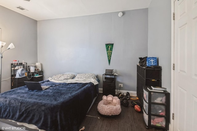 bedroom featuring wood finished floors, visible vents, and baseboards
