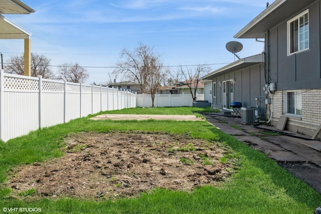 view of yard with central AC unit and fence