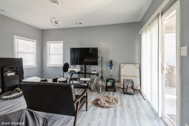 living room with visible vents, wood finished floors, and a wealth of natural light