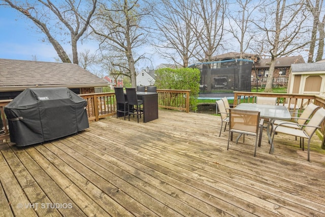 1127 Alpine Ln, Lemont, IL 60439 - wooden terrace featuring a trampoline, a grill, and outdoor dining space