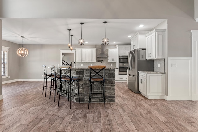 1101 Cascade Dr, Savoy, IL 61874 - kitchen featuring wall chimney range hood, stainless steel appliances, a kitchen bar, light wood-style floors, and tasteful backsplash