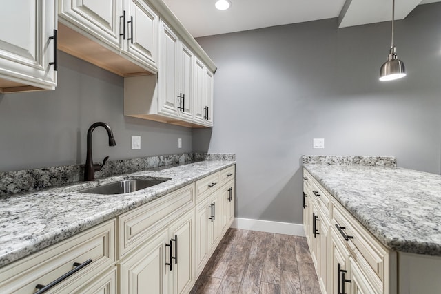 1101 Cascade Dr, Savoy, IL 61874 - kitchen with hanging light fixtures, wood finished floors, light stone countertops, recessed lighting, and a peninsula