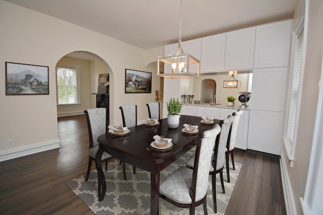 1005 Hovey Ave, Normal, IL 61761 - dining area featuring arched walkways, a notable chandelier, baseboards, and dark wood-style flooring