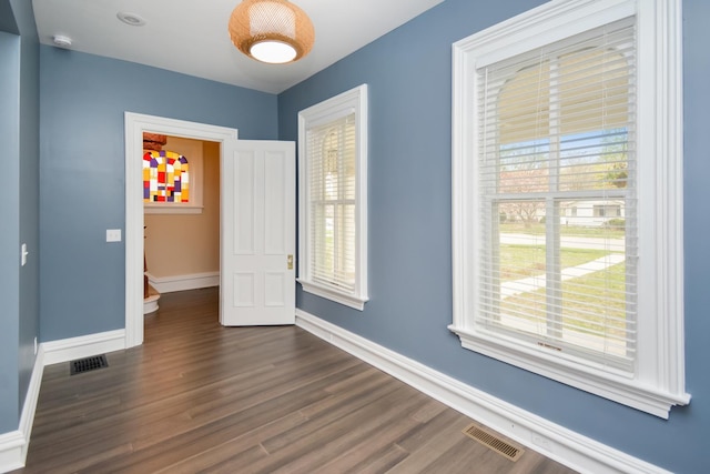 1005 Hovey Ave, Normal, IL 61761 - interior space featuring dark wood finished floors, baseboards, visible vents, and a wealth of natural light