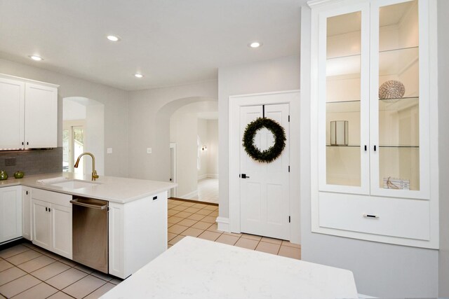 1005 Hovey Ave, Normal, IL 61761 - kitchen featuring stainless steel dishwasher, a sink, arched walkways, light countertops, and white cabinetry