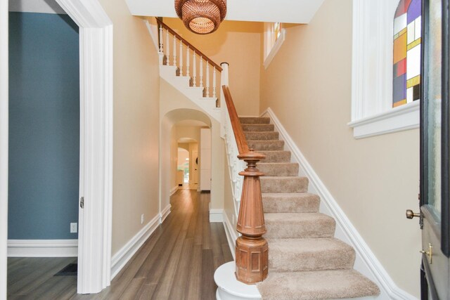 1005 Hovey Ave, Normal, IL 61761 - staircase featuring arched walkways, wood finished floors, and baseboards