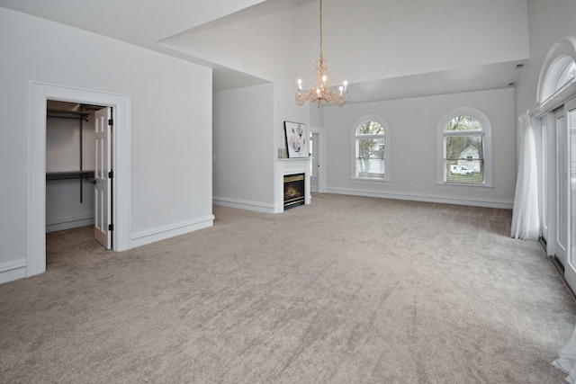 1005 Hovey Ave, Normal, IL 61761 - unfurnished living room with a glass covered fireplace, baseboards, carpet flooring, and a chandelier