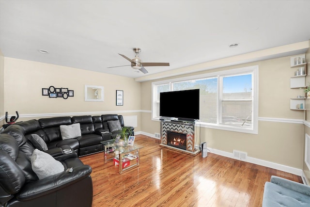 living room with baseboards, ceiling fan, wood finished floors, and visible vents
