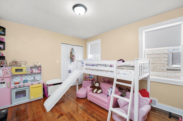bedroom featuring baseboards, wood finished floors, and a closet