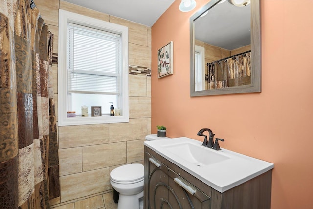 full bathroom featuring vanity, toilet, tile walls, a shower with shower curtain, and tile patterned floors