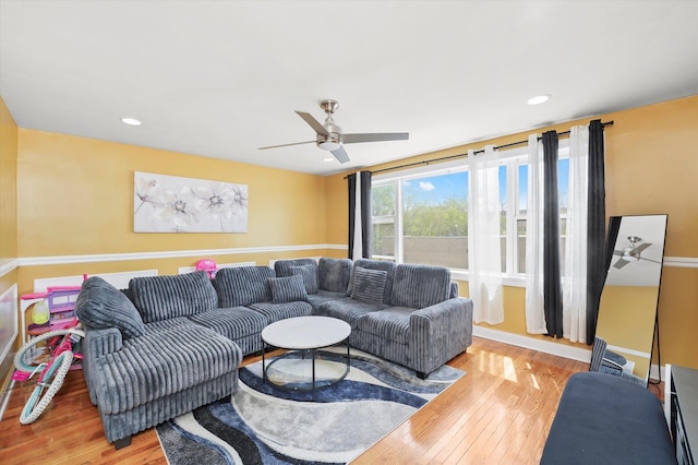 living area with wood-type flooring, a ceiling fan, and recessed lighting