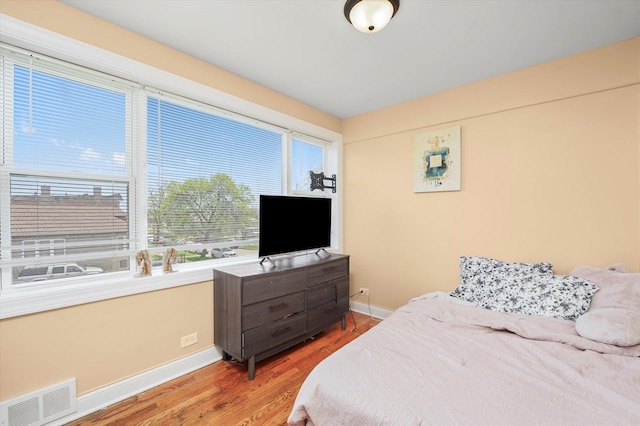 bedroom with visible vents, baseboards, and light wood-style floors