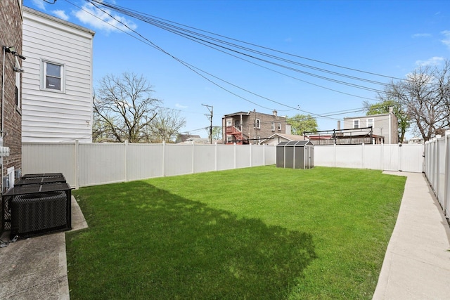 view of yard with a fenced backyard and central air condition unit