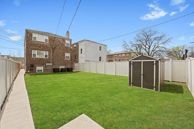 view of yard with a fenced backyard, an outdoor structure, central air condition unit, and a storage shed