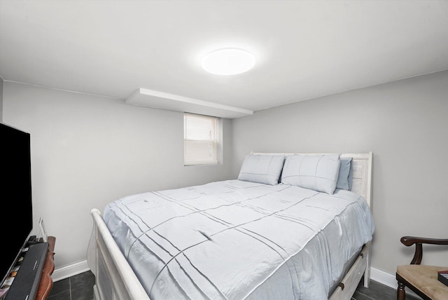 bedroom featuring baseboards and dark tile patterned floors