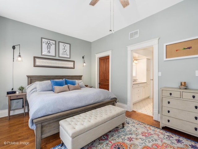 bedroom with light wood-style floors, baseboards, ensuite bath, and visible vents