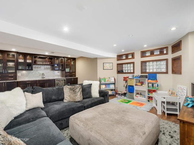 living room with indoor wet bar, recessed lighting, wine cooler, and wood finished floors