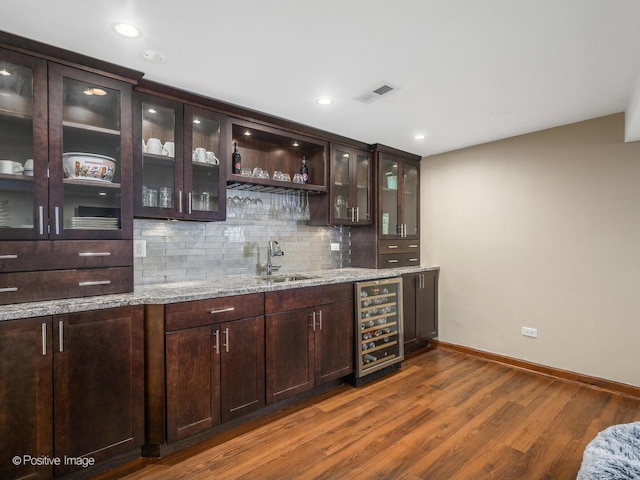 bar with visible vents, tasteful backsplash, a sink, dark wood-style floors, and wine cooler