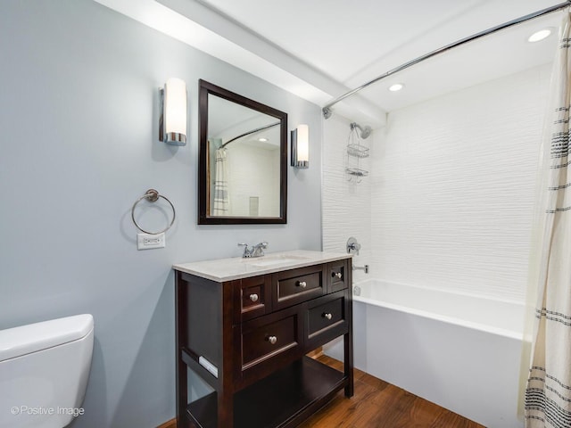 bathroom featuring vanity, wood finished floors, toilet, recessed lighting, and shower / tub combo
