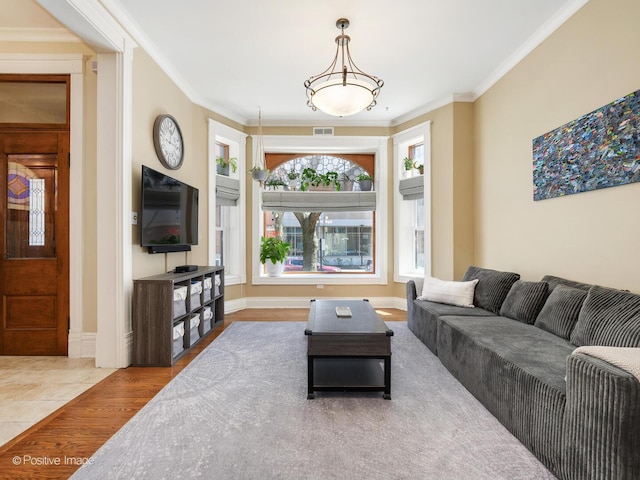 living area featuring visible vents, ornamental molding, and wood finished floors