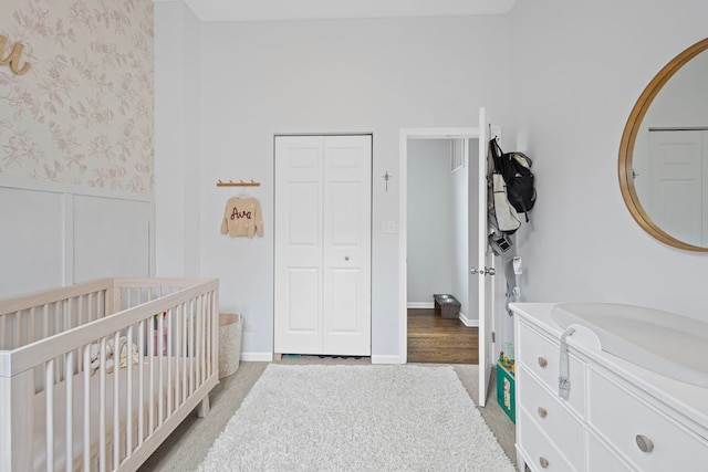 1942 W Armitage Ave Unit 2, Chicago, IL 60622 - bedroom featuring a wainscoted wall, a nursery area, a closet, light carpet, and wallpapered walls