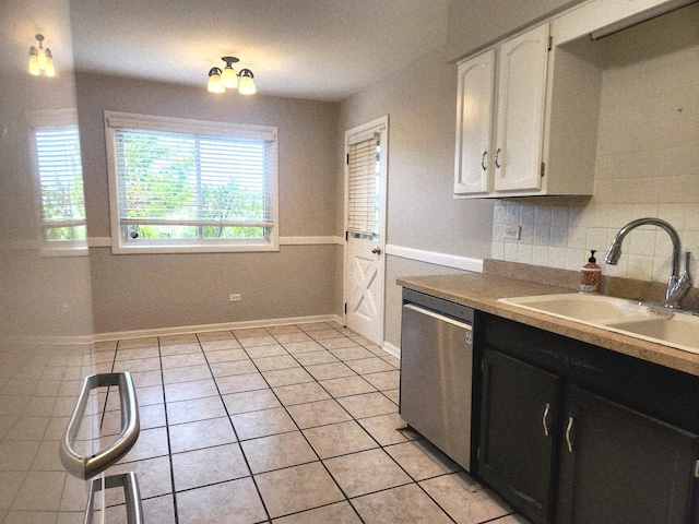 kitchen featuring dishwasher, a sink, white cabinetry, light tile patterned floors, and dark cabinets