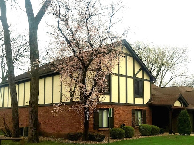 view of side of home featuring stucco siding and brick siding