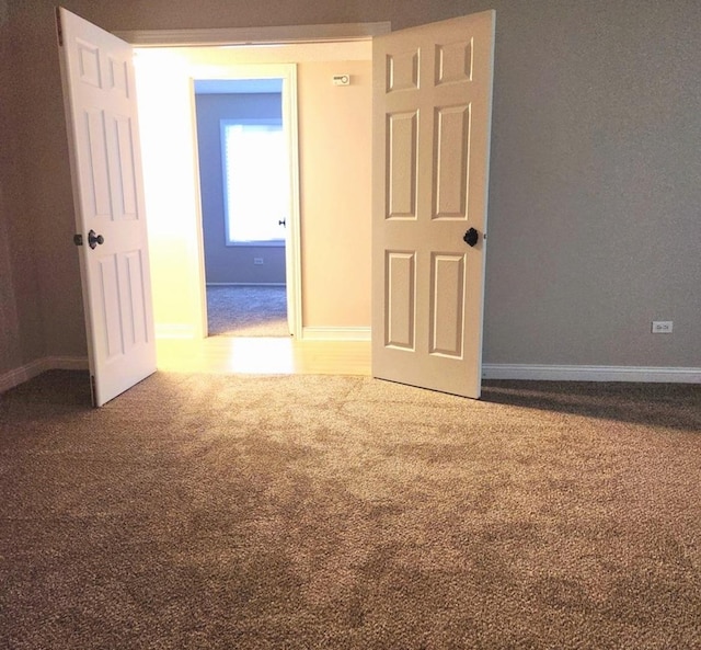 carpeted spare room with baseboards