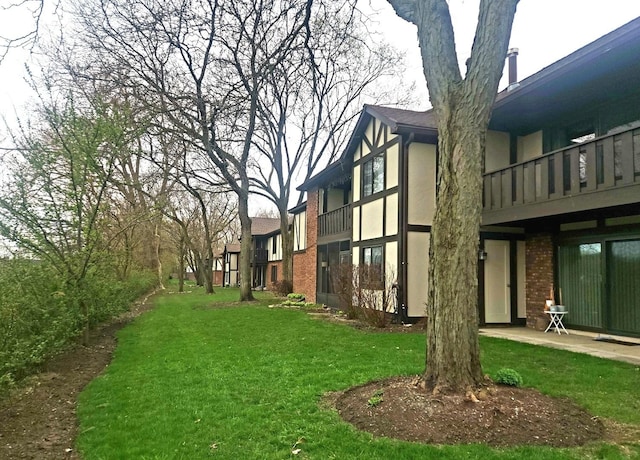 view of green lawn with a balcony