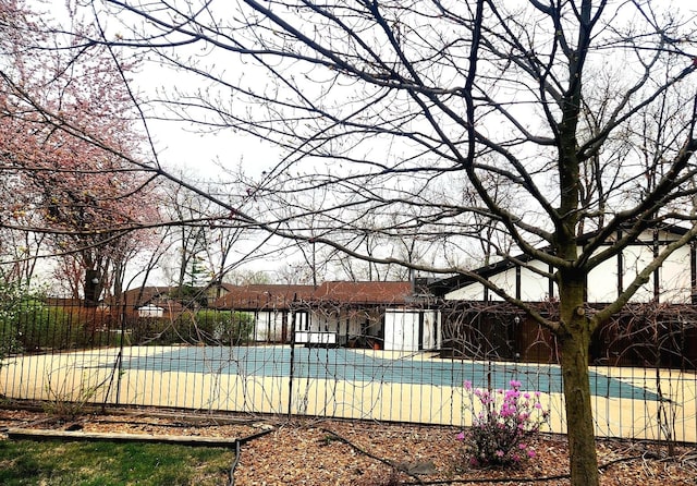 view of pool featuring fence and basketball hoop