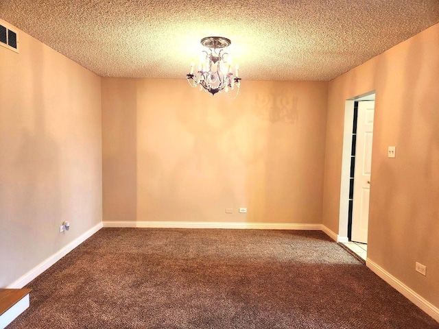 carpeted spare room with a chandelier, a textured ceiling, and baseboards