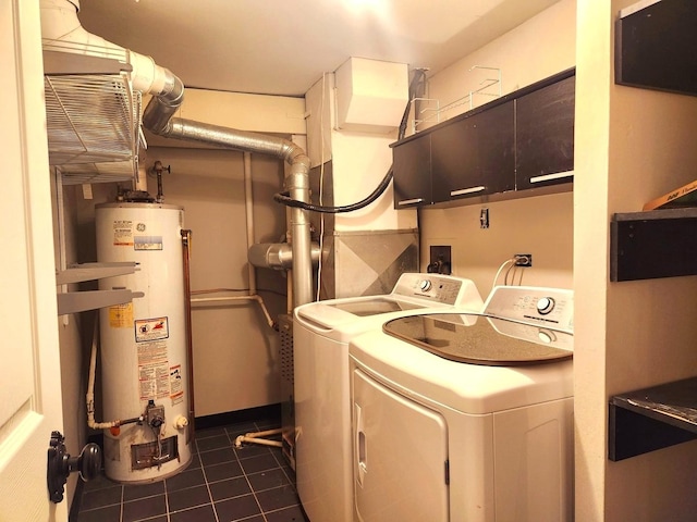 washroom featuring water heater, washer and clothes dryer, and dark tile patterned flooring