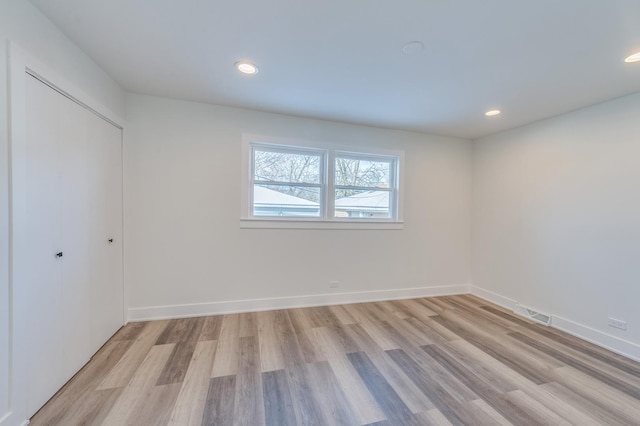 spare room featuring baseboards, recessed lighting, and light wood-style flooring