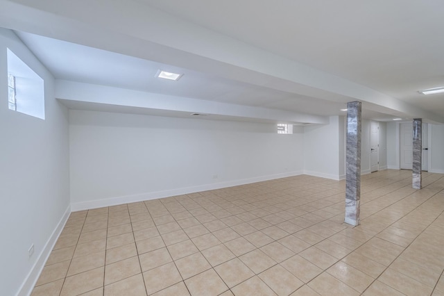 finished basement featuring baseboards and light tile patterned floors