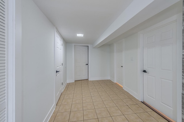 hallway with light tile patterned flooring and baseboards