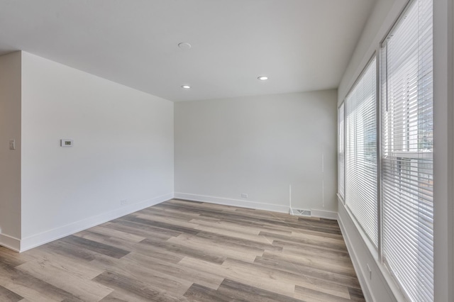 unfurnished room featuring recessed lighting, light wood-style floors, visible vents, and baseboards