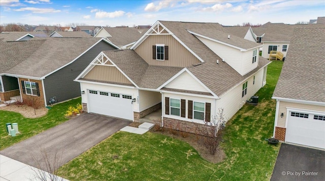 view of front facade with an attached garage, aphalt driveway, stone siding, and board and batten siding