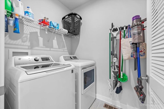 washroom featuring baseboards, washer and clothes dryer, and laundry area