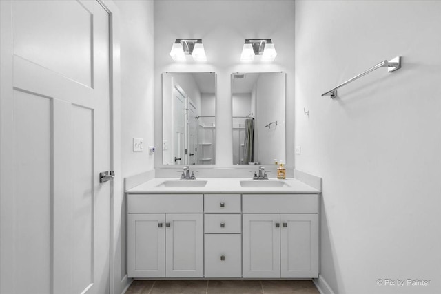 bathroom featuring tile patterned floors, a sink, and double vanity